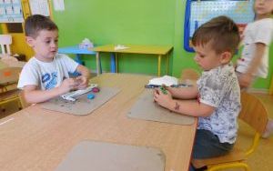 Chłopcy z grupy 4-latków lepią z plasteliny przy stoliku