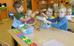 Grupa dzieci 5-letnich bawi się klockami przy stoliku