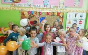 Dzieci z gr. 4-l stoją przy dekoracji z okazji Dnia Przedszkolaka