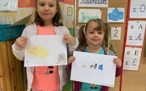 Nina i Magda pokazują ilustracje ze swoimi zwierzęcymi ulubieńcami