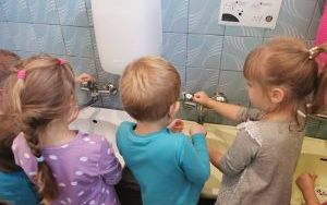 Grupa dzieci w łazience myje ręce
